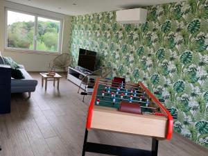 a living room with a foos ball on a table at Le Relais de la Fontaine & Jacuzzi in Montcornet