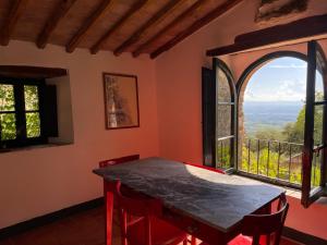 a dining room with a table and a large window at Agriturismo Cetamura in Castelnuovo Berardenga