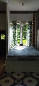 ein großes Bett in einem Schlafzimmer mit Fenster in der Unterkunft Ulęgałki Roztocze Stodoła in Jacnia