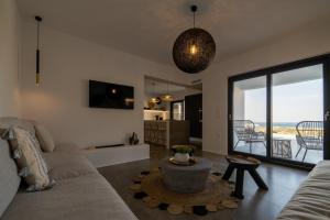 uma sala de estar com um sofá e vista para o oceano em Villa Unica - Mikri Vigla, Seaview, Pool & Jacuzzi em Mikri Vigla