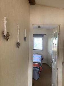 a bedroom with a bed and a door to a room at Thornwick Bay Haven Site-Large Homely Static Caravan, Sun, Sea And Sand (SEA VEIWS , LIGHTHOUSE VEIWS) in Flamborough