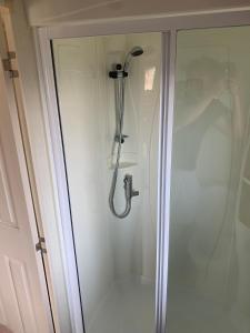 a shower with a glass door in a bathroom at Thornwick Bay Haven Site-Large Homely Static Caravan, Sun, Sea And Sand (SEA VEIWS , LIGHTHOUSE VEIWS) in Flamborough