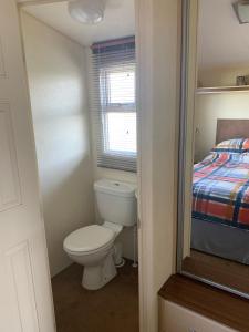 a small bathroom with a toilet and a bed at Thornwick Bay Haven Site-Large Homely Static Caravan, Sun, Sea And Sand (SEA VEIWS , LIGHTHOUSE VEIWS) in Flamborough
