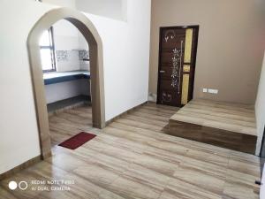 Habitación con pasillo con puerta y suelo de baldosa. en Yog Bhawan, en Greater Noida