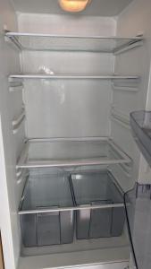 um frigorífico vazio com a porta aberta e as prateleiras vazias em Park Home at Golden Sands Holiday Park em Foryd