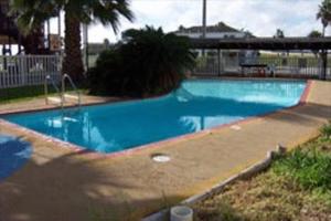 a large blue swimming pool with a bridge in the background at Knights Inn Corpus Christi in Corpus Christi