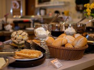 uma mesa coberta com cestas de pão e taças de vinho em Alameda Alegra Hotel em Gramado
