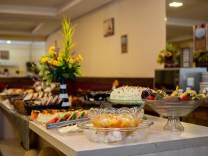 un buffet con muchos tipos diferentes de comida en una mesa en Alameda Alegra Hotel en Gramado