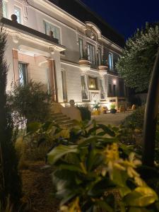 a large white house at night with lights at Le Passagran in Boën