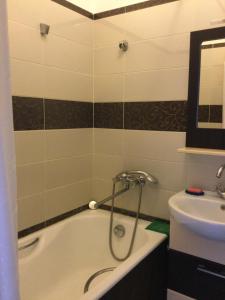 a bathroom with a bath tub and a sink at Apartment Na Lidzava Beach in Pizunda