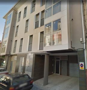 un bâtiment avec une voiture garée devant lui dans l'établissement Apartament Ramon a Pobla, à Pobla de Segur