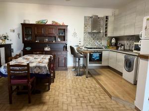 a kitchen with a table and a dining room at Villetta dei Tramonti in Trappeto