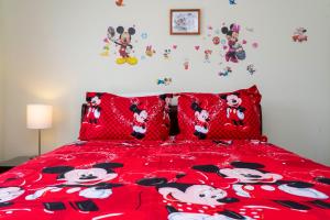 a bedroom with a red bed with mickey mouse pillows at 7 Bedroom Mansion Near Disney in Kissimmee