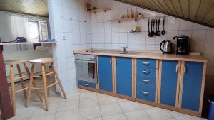 a kitchen with blue cabinets and a sink at House Elan in Kornić