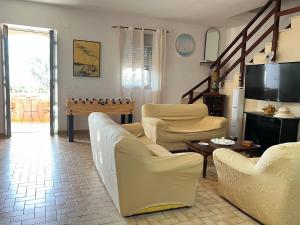 a living room with chairs and a table and a television at Villetta dei Tramonti in Trappeto