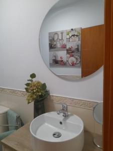 bagno con lavandino bianco e specchio di Arode Apartamento a Los Abrigos