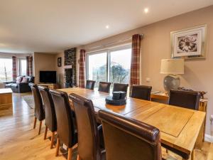 a dining room with a large wooden table and chairs at Luxury Highland Home in Scotlands' Great Glen in Gairlochy +2 photos