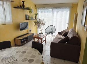 uma sala de estar com um sofá e uma mesa em Résidence Floria em La Baule