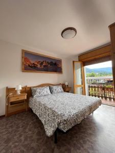 um quarto com uma cama e uma janela com vista em DOLOMITI HOUSE 4 em Fiera di Primiero