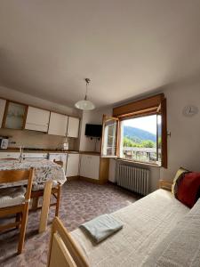 um quarto com uma cozinha, uma mesa e uma janela em DOLOMITI HOUSE 4 em Fiera di Primiero