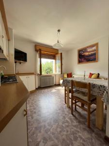 uma cozinha e uma sala de jantar com uma mesa em DOLOMITI HOUSE 4 em Fiera di Primiero
