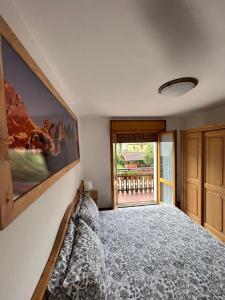 a bedroom with a bed and a wall with a window at DOLOMITI HOUSE 4 in Fiera di Primiero