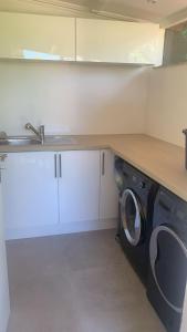 a kitchen with a washing machine under a counter at Villa ANOLPA in Vence