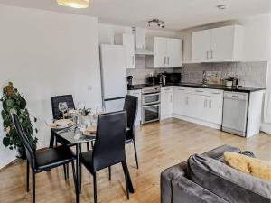 a kitchen and living room with a table and chairs at Comfy 2 bed Flat with free Parking, close to Tube in Woolwich