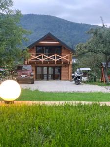 a log cabin with a motorcycle parked in front of it at Guculka Apartments in Yaremche