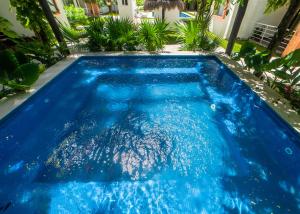 a swimming pool with blue water in a yard at Cancun Airport Condo Hotel Apartment with pool and security in Cancún