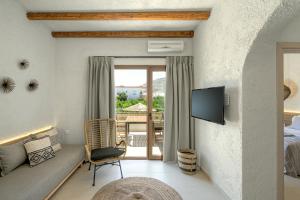 a living room with a couch and a tv at Okeanis Mystique South in Ierápetra