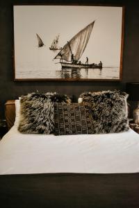 a bed with a pillow and a picture of a boat at Cwebile Guesthouse in Winterton