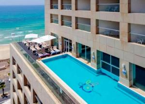een uitzicht over een hotel met een zwembad en de oceaan bij 8 Hotel Apartment Short Time TLV BAT YAM in Bat Yam