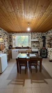 cocina con techo de madera, mesa y sillas en Private Country-House, en Keratokampos