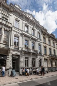 un gran edificio blanco con gente sentada fuera de él en Jacob’s Getaway, en Gante