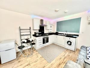 a kitchen with a sink and a washing machine at Lt Properties Luton town centre studio Tv Netflix Ground Floor 2 in Luton