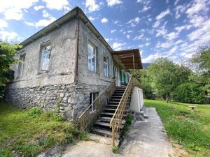 an old stone house with stairs leading up to it at Authentic house with a huge garden in Utsera