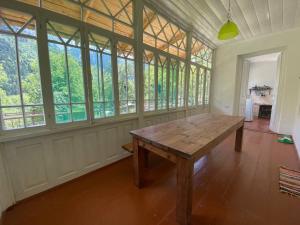 a large room with a wooden table and windows at Authentic house with a huge garden in Utsera +45 photos