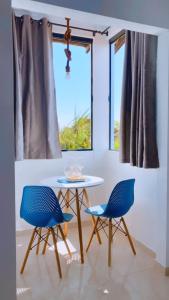 a table and two chairs in front of a window at Mar&Brisa Hospedagem in Penha