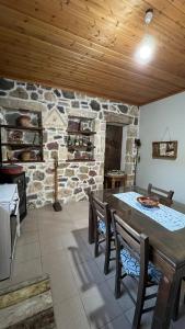cocina con mesa y pared de piedra en Private Country-House, en Keratokampos