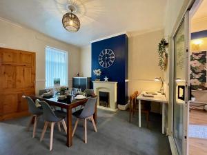a dining room with a table and chairs and a fireplace at Kimberworth House, 4 Bedrooms, WIFI, Close to M1, Longer Stay, Free Parking in Rotherham