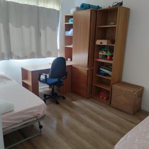 a bedroom with a desk and a bed and a chair at Apartment close to the beach with free parking in Badalona