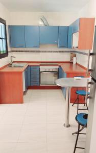 a kitchen with blue cabinets and a table and chairs at Casa Cris in La Lajita