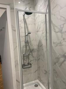 La salle de bains est pourvue d'une douche avec une porte en verre. dans l'établissement Rancy, à Lyon