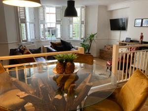 a living room with a glass table and chairs at Olive Tree Apartment Hove in Brighton & Hove
