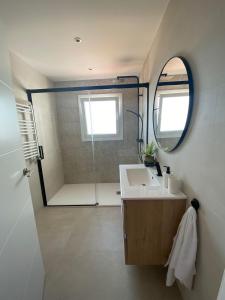a bathroom with a sink and a shower with a mirror at Villa Casa Blanca in Blanes