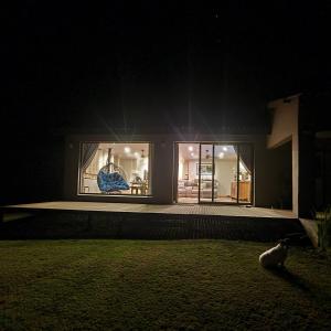 a cat sitting in front of a house at night at Luxury Home with breathtaking views of Champagne Valley in Bergview