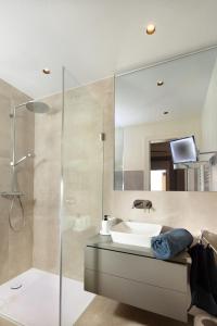 ein Bad mit einem Waschbecken und einer Glasdusche in der Unterkunft Warnemünde: Apartment KAJÜTE - nur 3 Gehminuten zum Strand in Warnemünde