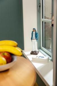 a toy figure sitting on a window sill next to a bowl of fruit at Warnemünde: Apartment KAJÜTE - nur 3 Gehminuten zum Strand in Warnemünde