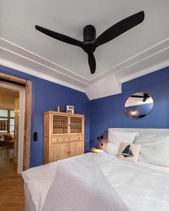 - une chambre bleue avec un lit et un ventilateur de plafond dans l'établissement Warnemünde: Apartment KAJÜTE - nur 3 Gehminuten zum Strand, à Warnemünde